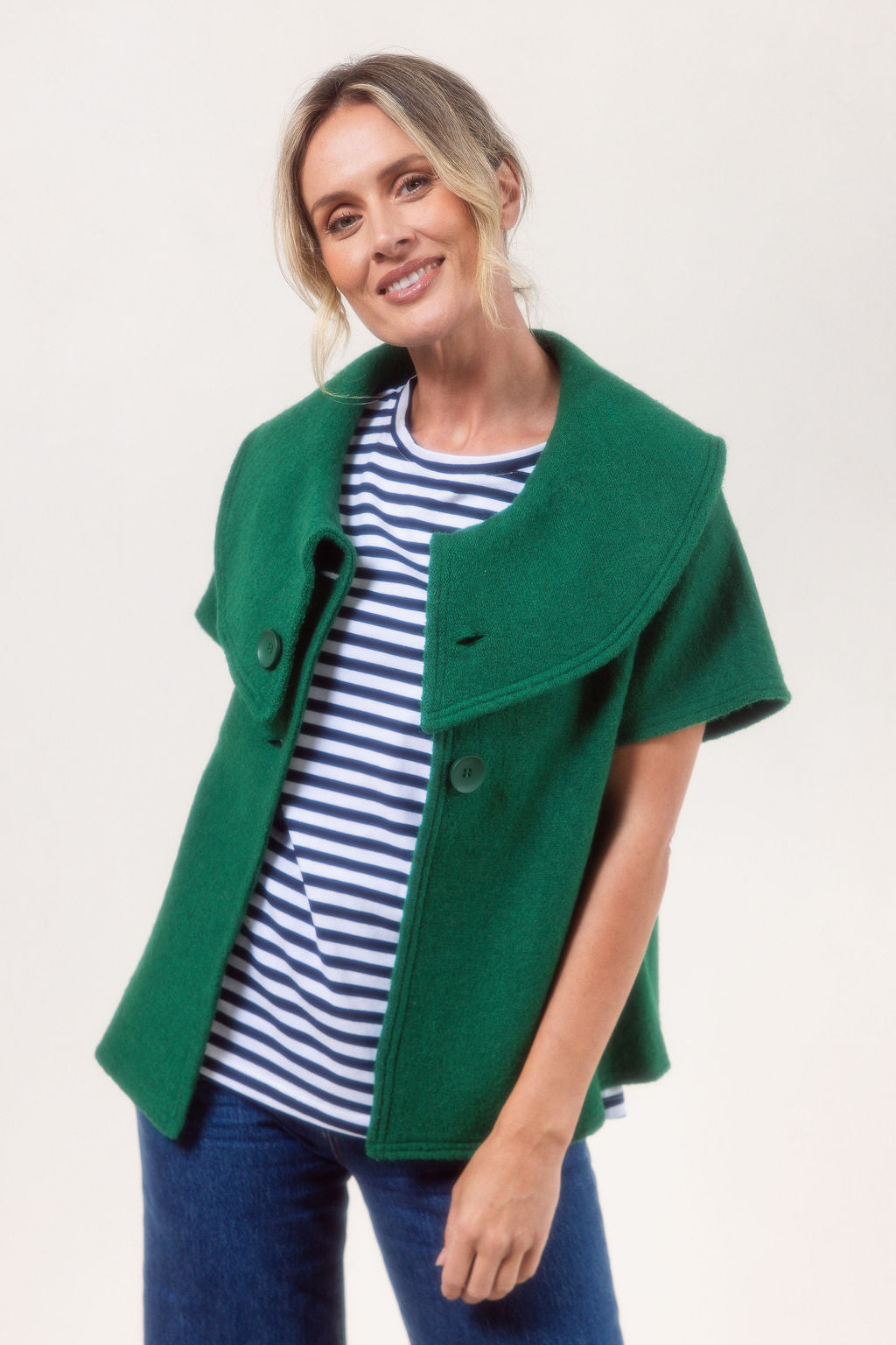 Woman wearing a See Saw Boiled Wool green coat against a plain background.