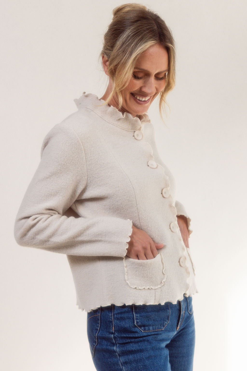 Woman wearing a See Saw cream-colored boiled wool jacket with a white background