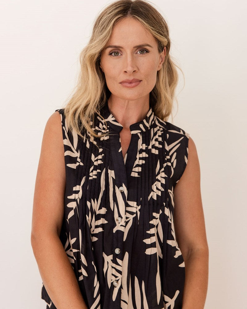 Woman wearing a black sleeveless dress with white floral pattern against a plain background. See Saw Cotton Sleeveless Pintuck Top