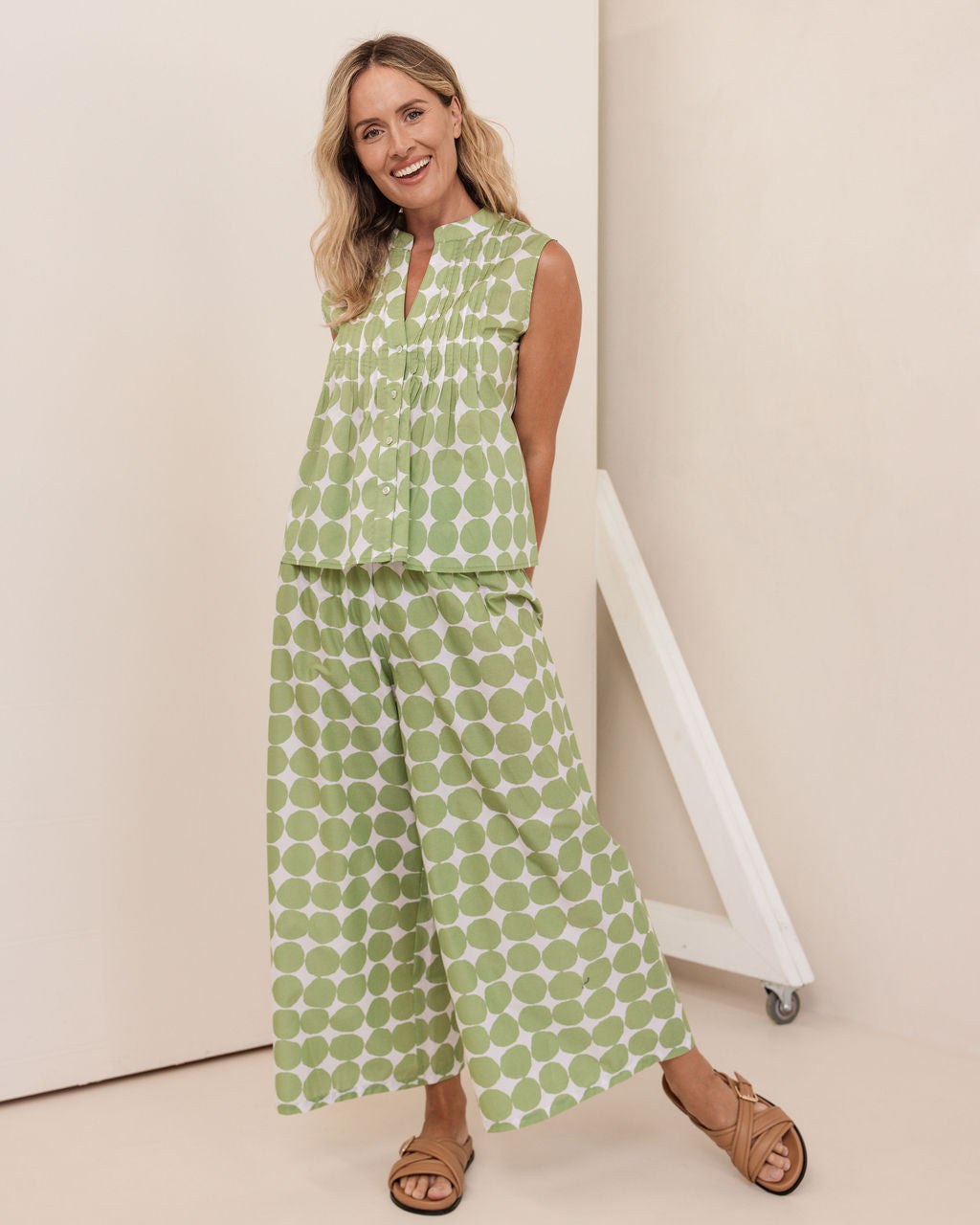 Woman wearing a green patterned outfit standing against a white wall. See Saw Cotton Shirred Waist Pant & Cotton Sleeveless Pintuck Top