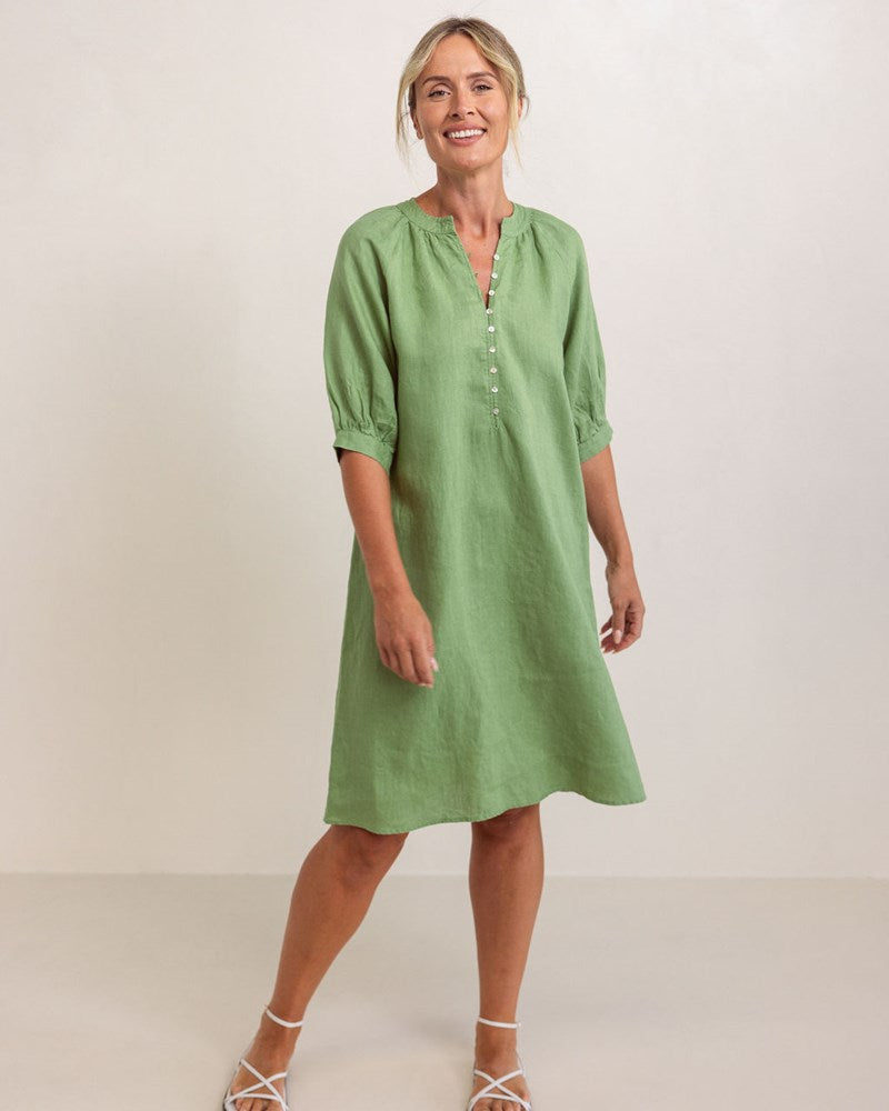 Woman wearing a see saw linen dress with button detail in pistachio colour against a plain background See Saw Linen Cuff Sleeve Dress
