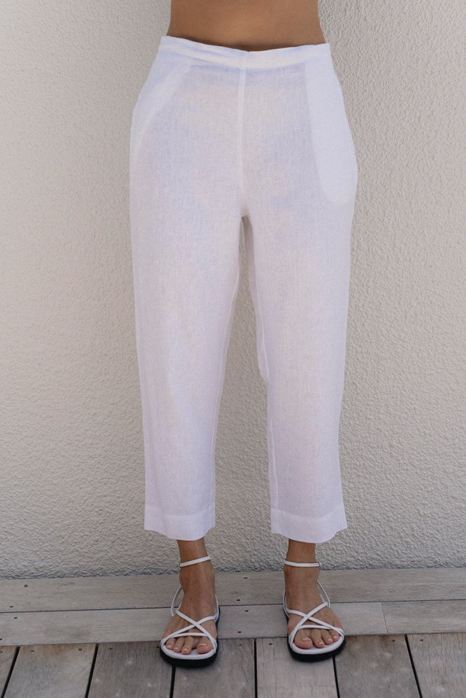 White pants worn by a person standing against a plain wall. See Saw 7/8 Length Pull On Pant