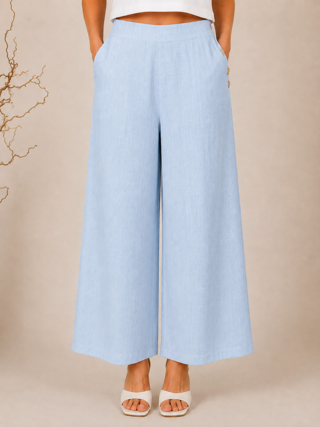 White wide-leg See Saw Palazzo linen pants shown on a model wearing white heeled sandals against a light beige background.
