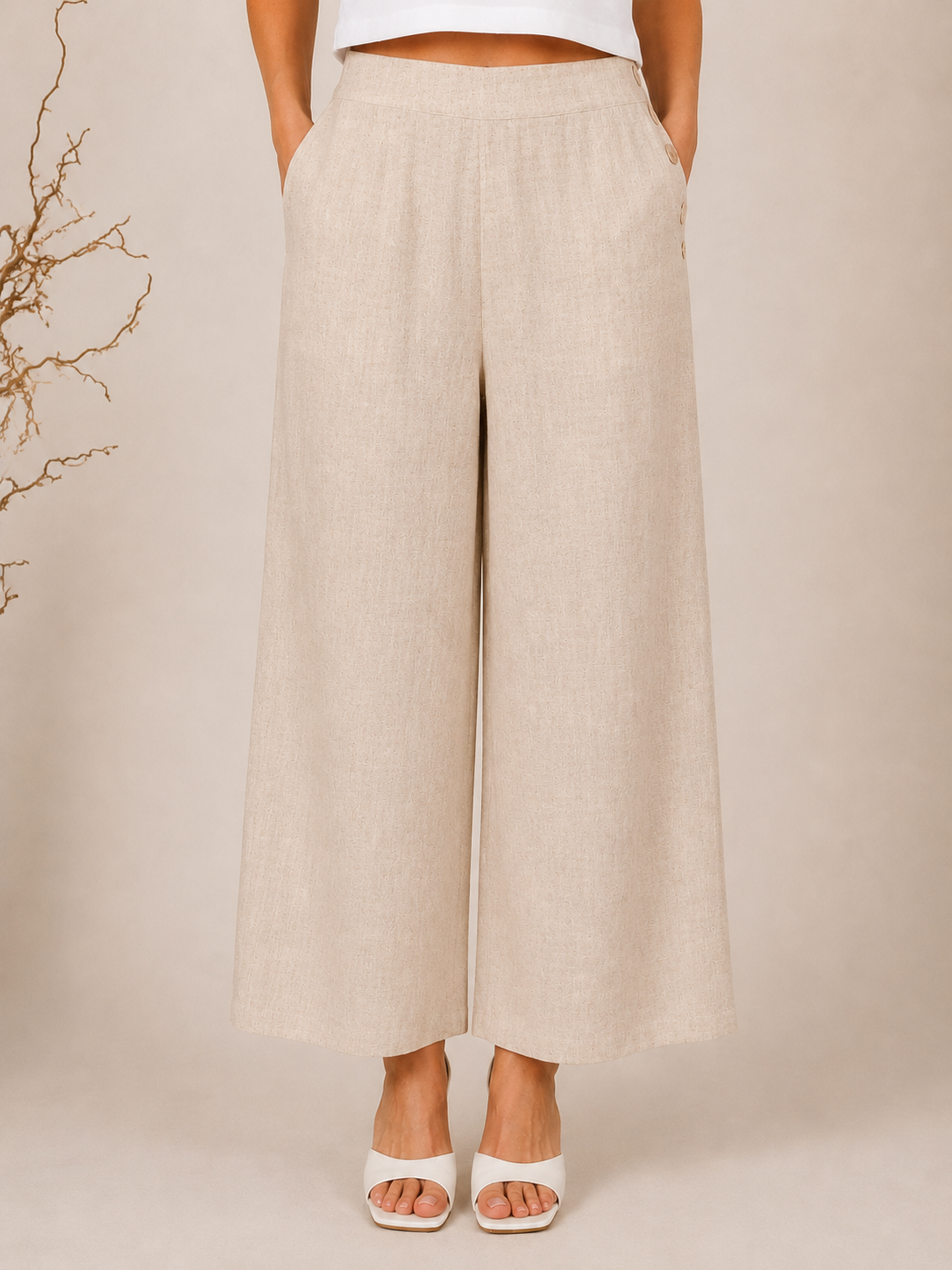 White wide-leg See Saw Palazzo linen pants shown on a model wearing white heeled sandals against a light beige background.