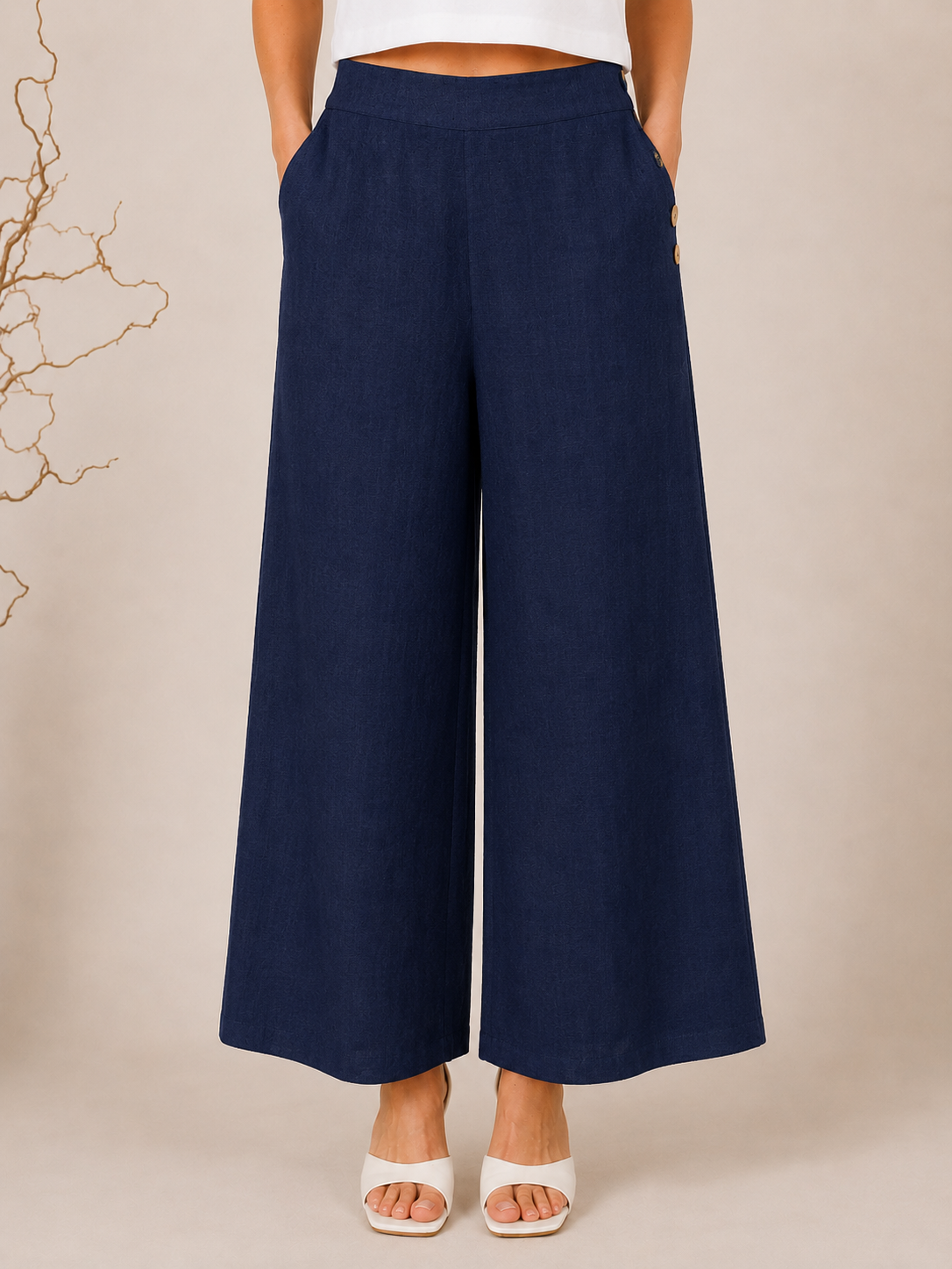 White wide-leg See Saw Palazzo linen pants shown on a model wearing white heeled sandals against a light beige background.