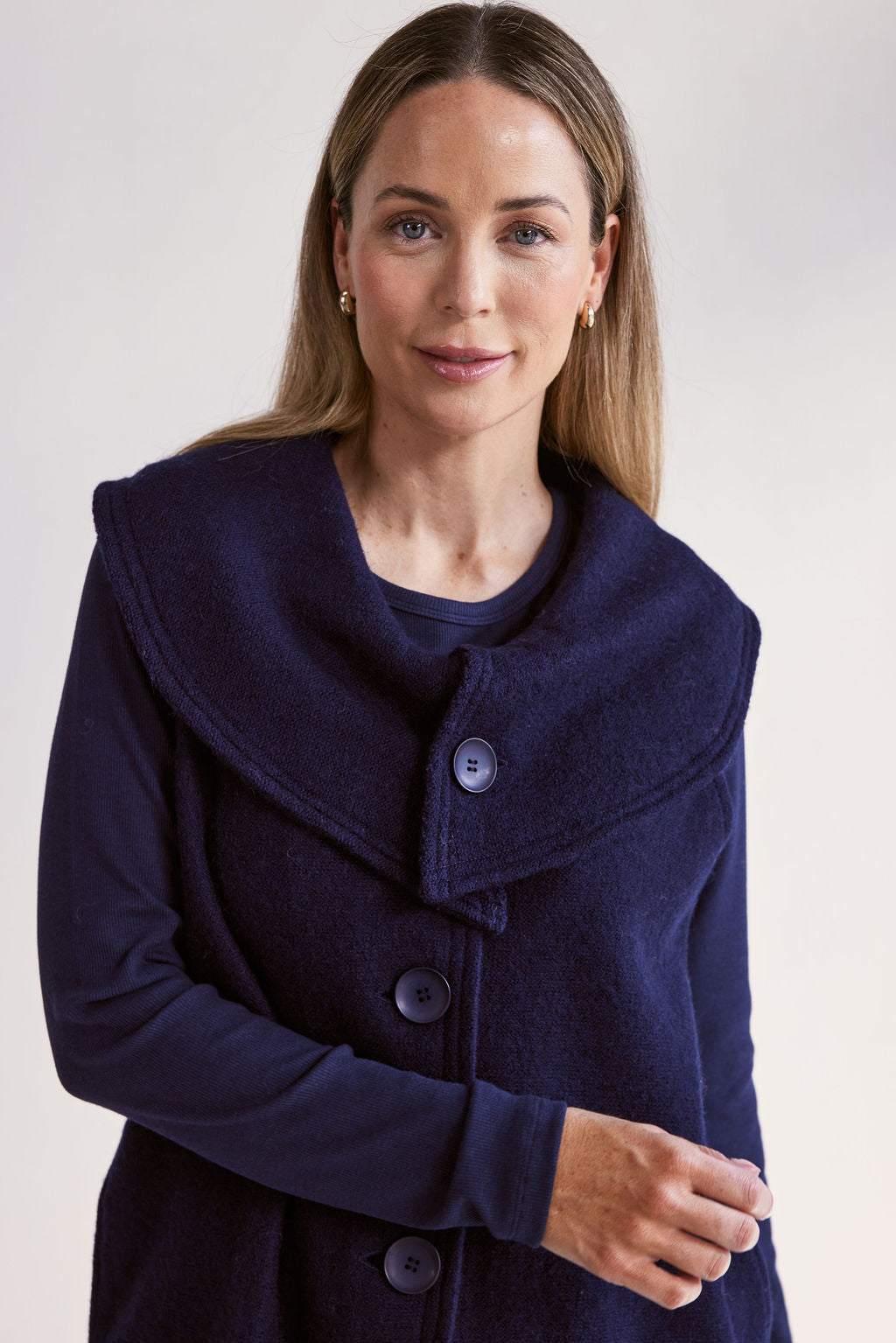 Woman wearing a navy blue See Saw Boiled Wool Vest on a white background