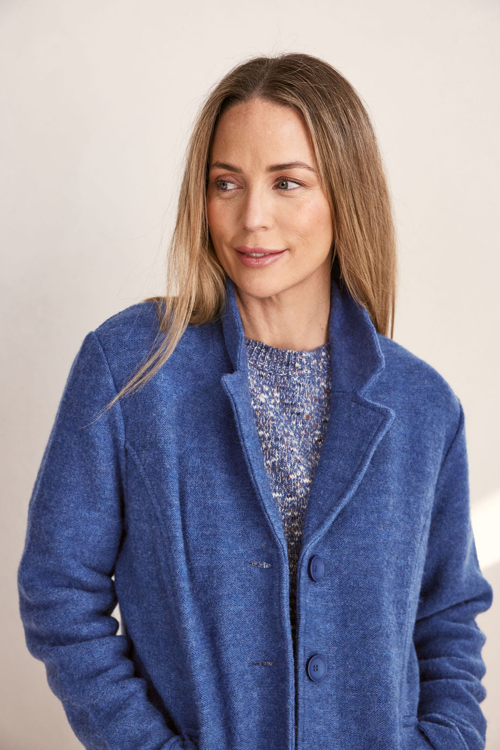 Woman wearing green boiled wool See Saw blazer in denim with a white background