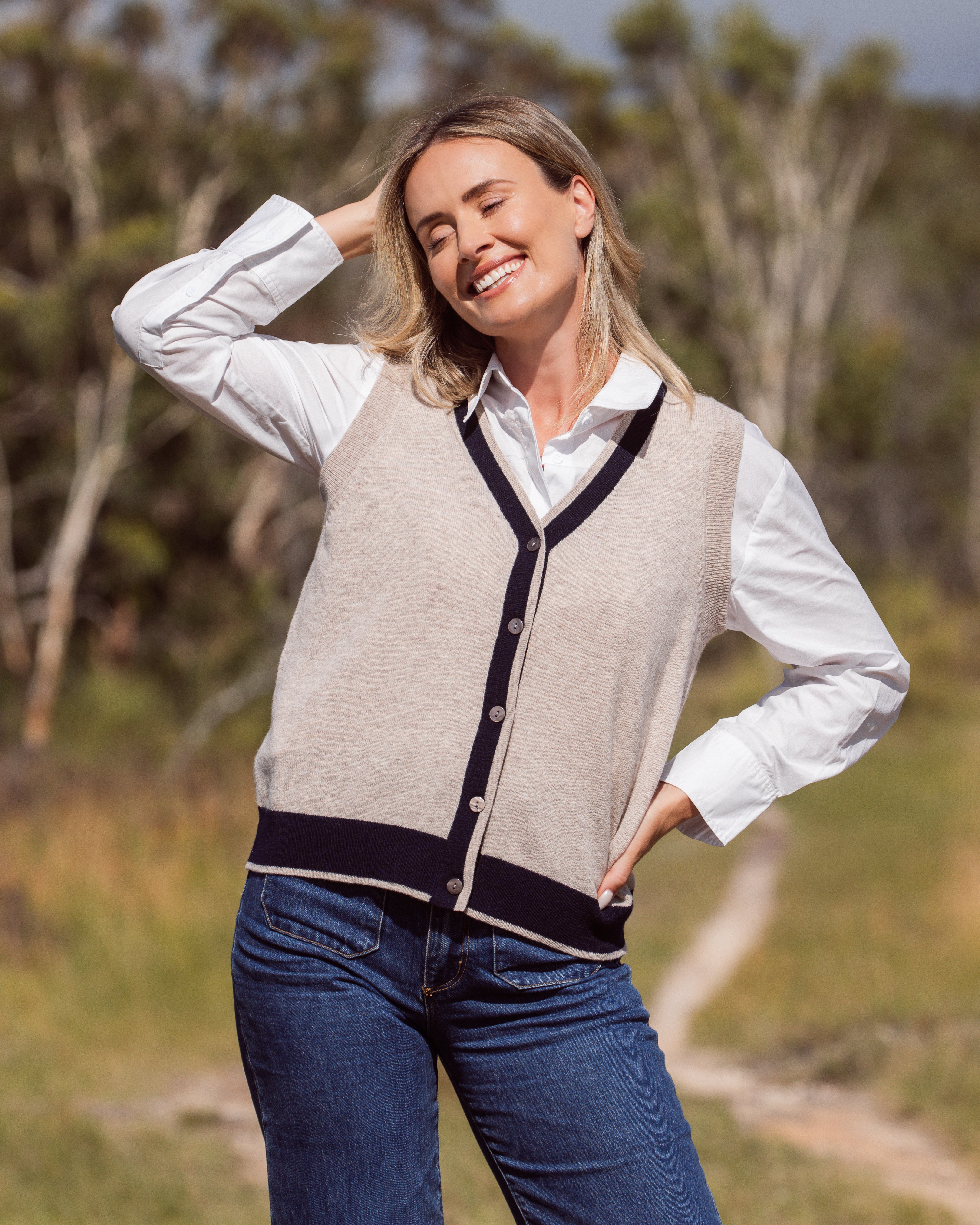 Woman wearing a Merino Wool See Saw beige vest with navy trim outdoors