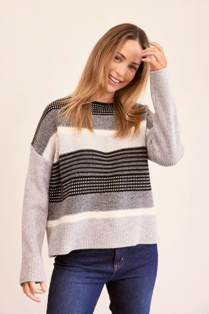Woman wearing a jacquard patterned See Saw sweater against a plain background