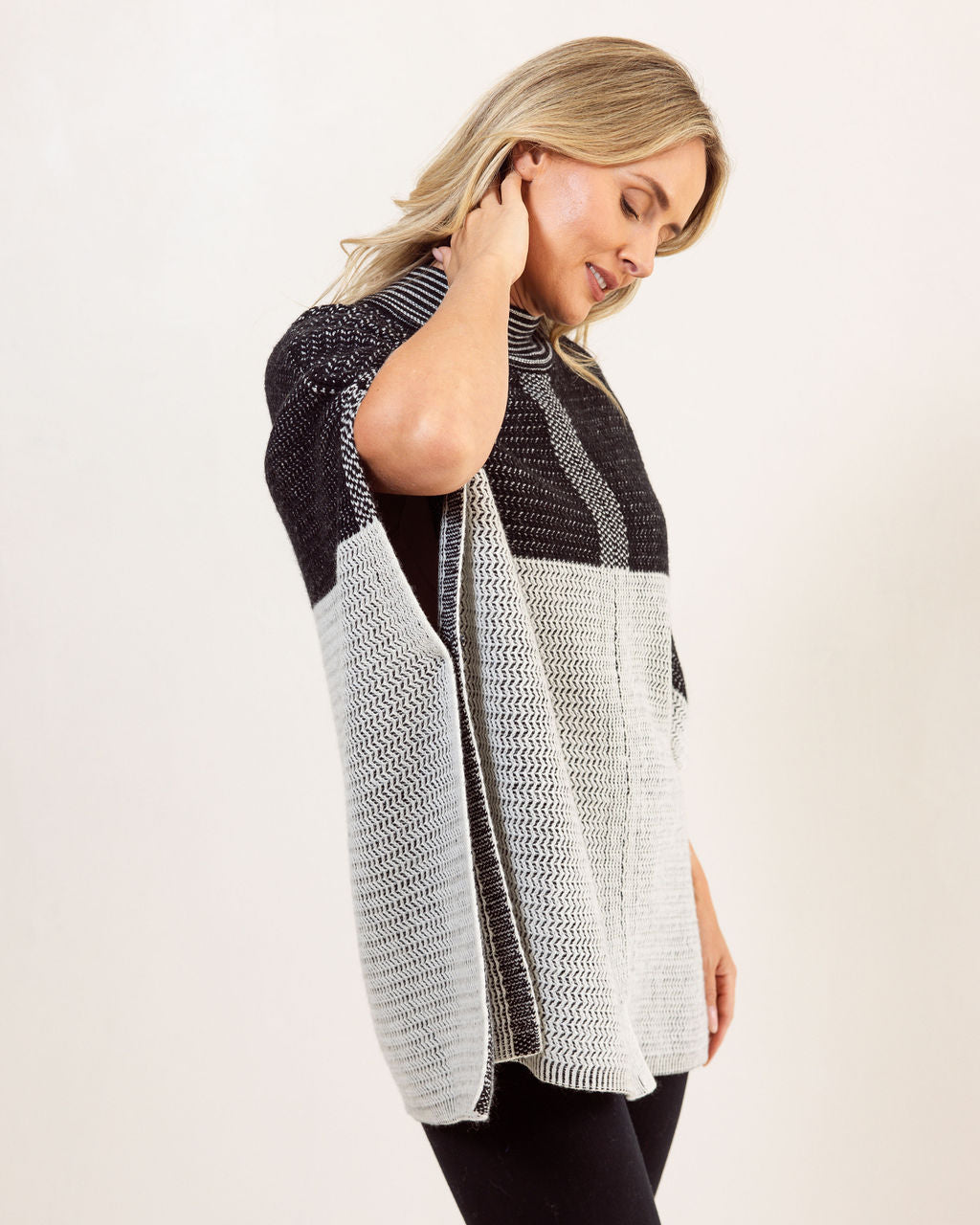 Woman wearing a black and gray See Saw Wool patterned poncho against a white background
