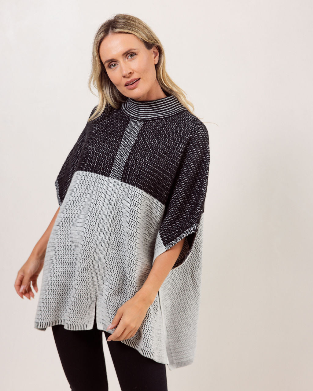 Woman wearing a black and gray See Saw Wool patterned poncho against a white background