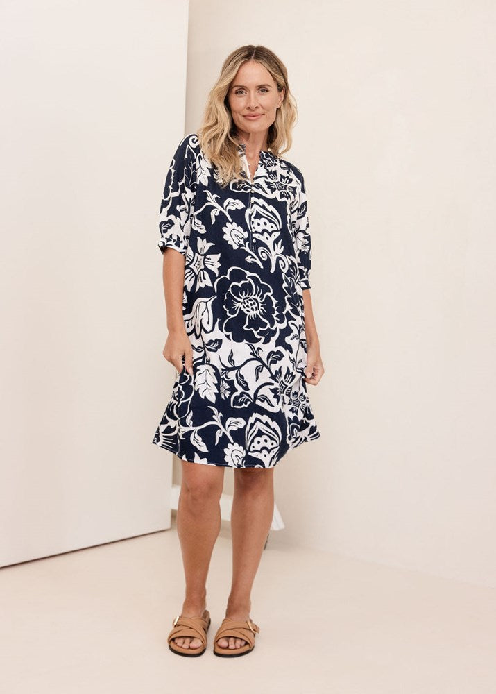 Woman wearing a navy See Saw Linen floral dress against a white background