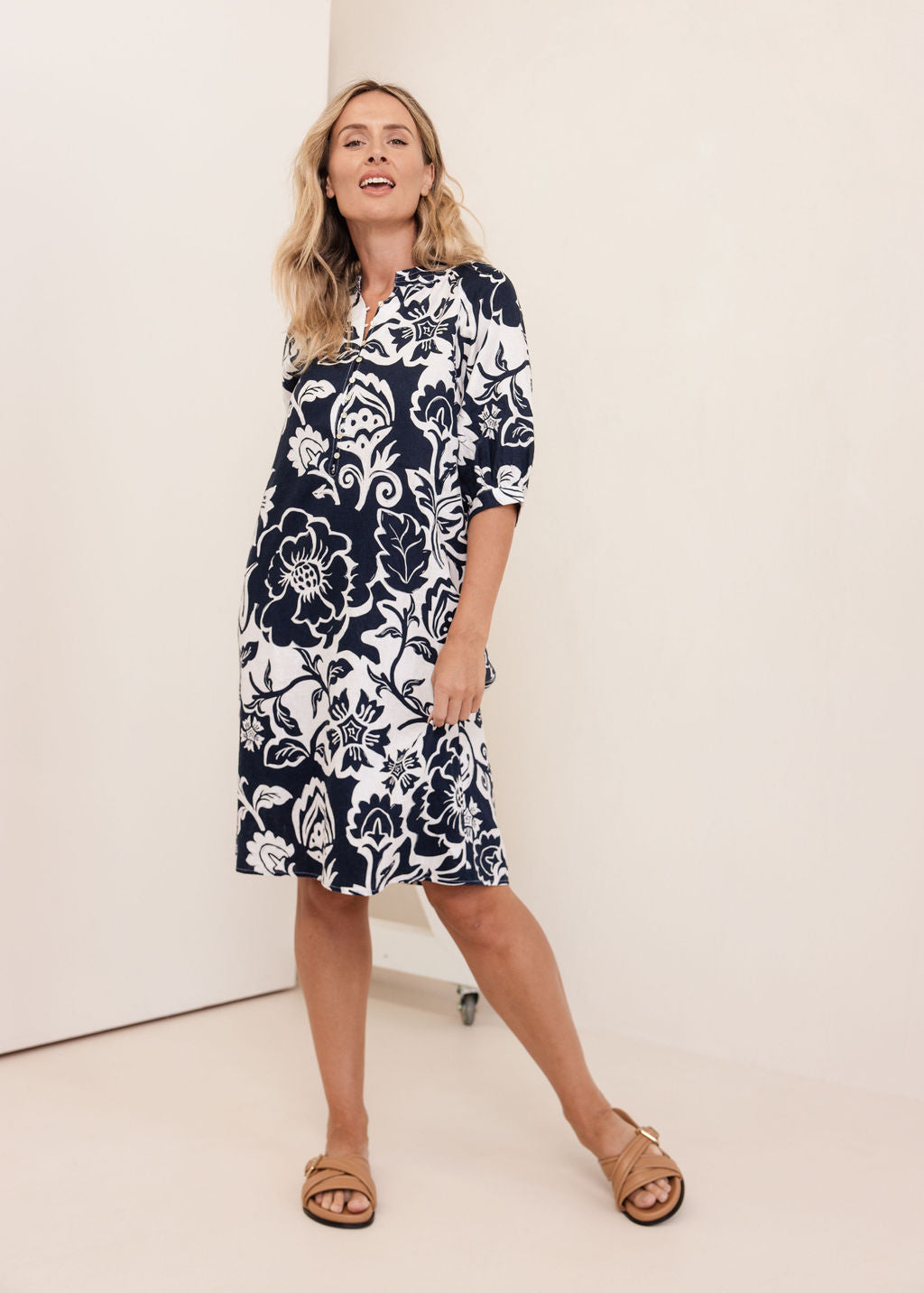 Woman wearing a navy See Saw Linen floral dress against a white background