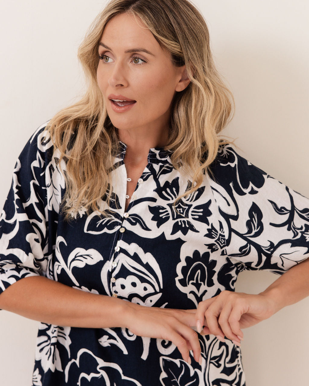 Woman wearing a navy See Saw Linen floral dress against a white background