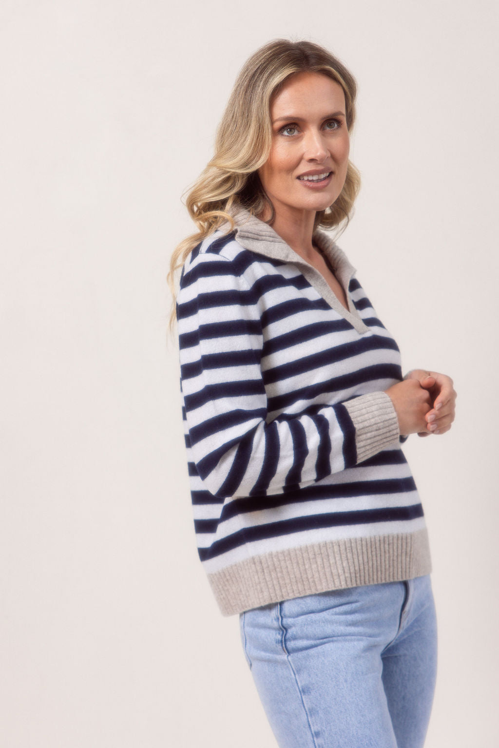 Woman wearing a see Saw Merino Wool navy and white striped sweater with a light gray collar against a plain background