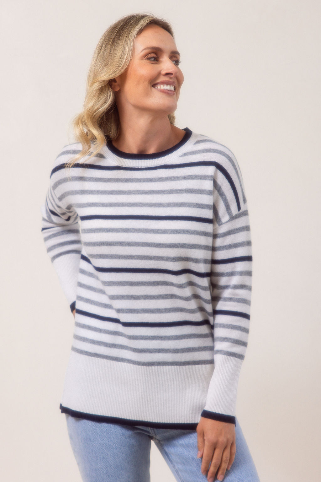 Woman wearing a Merino Wool striped See Saw sweater against a plain background