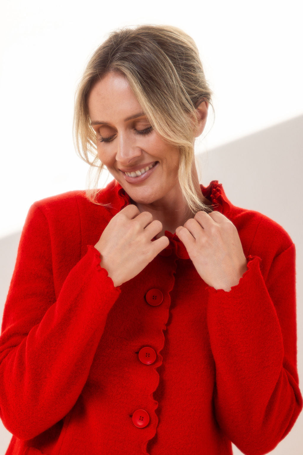 Woman wearing a See Saw red-colored boiled wool jacket with a white background