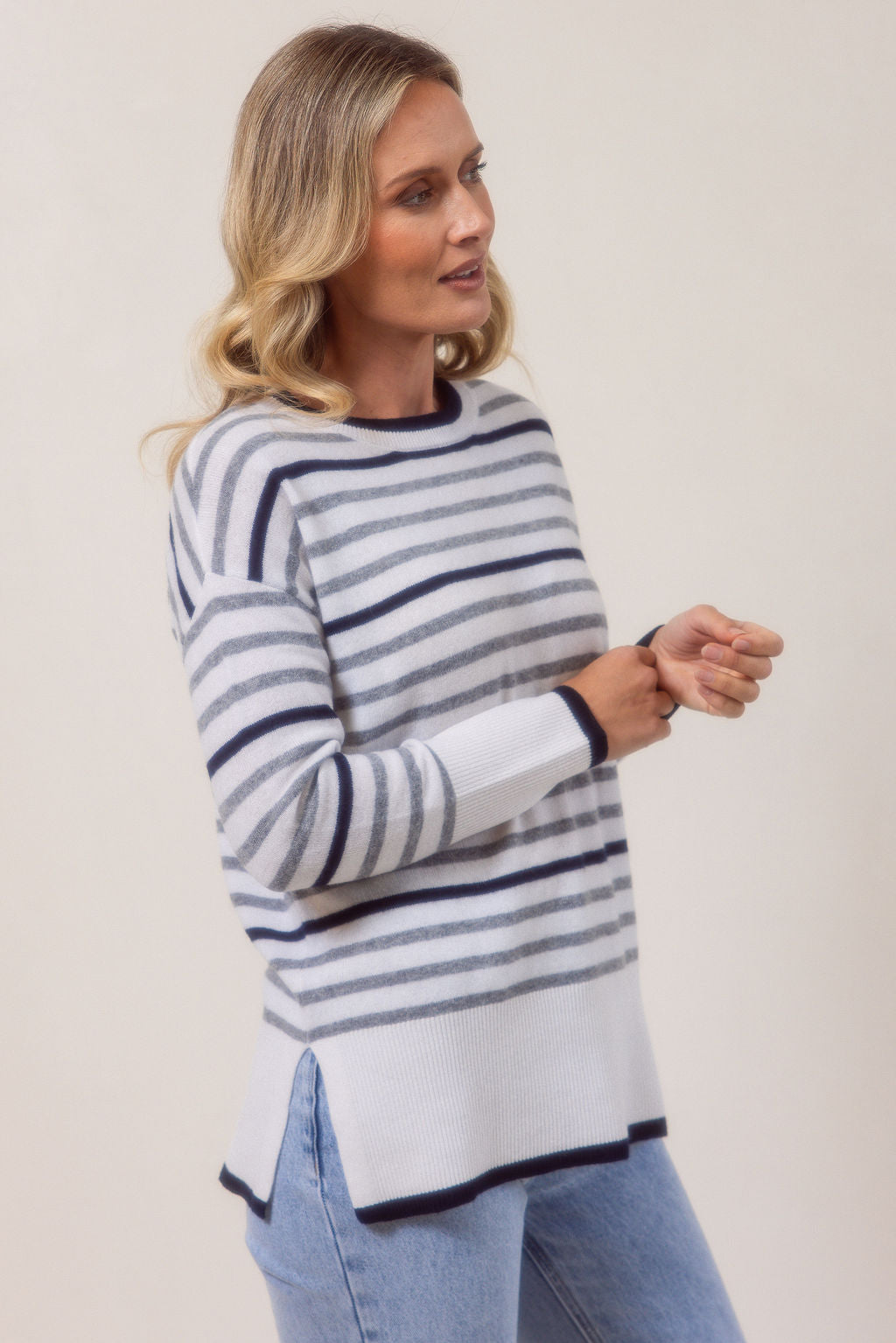 Woman wearing a Merino Wool striped See Saw sweater against a plain background