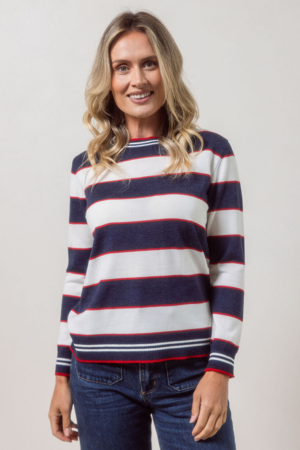Woman wearing a striped merino wool See Saw sweater with a plain background