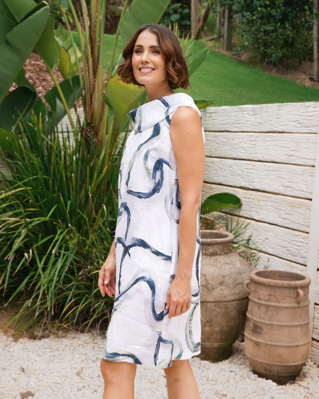 Model wears See Saw signature dress with cowl neck. Dress is in See Saw signature print riverstone.