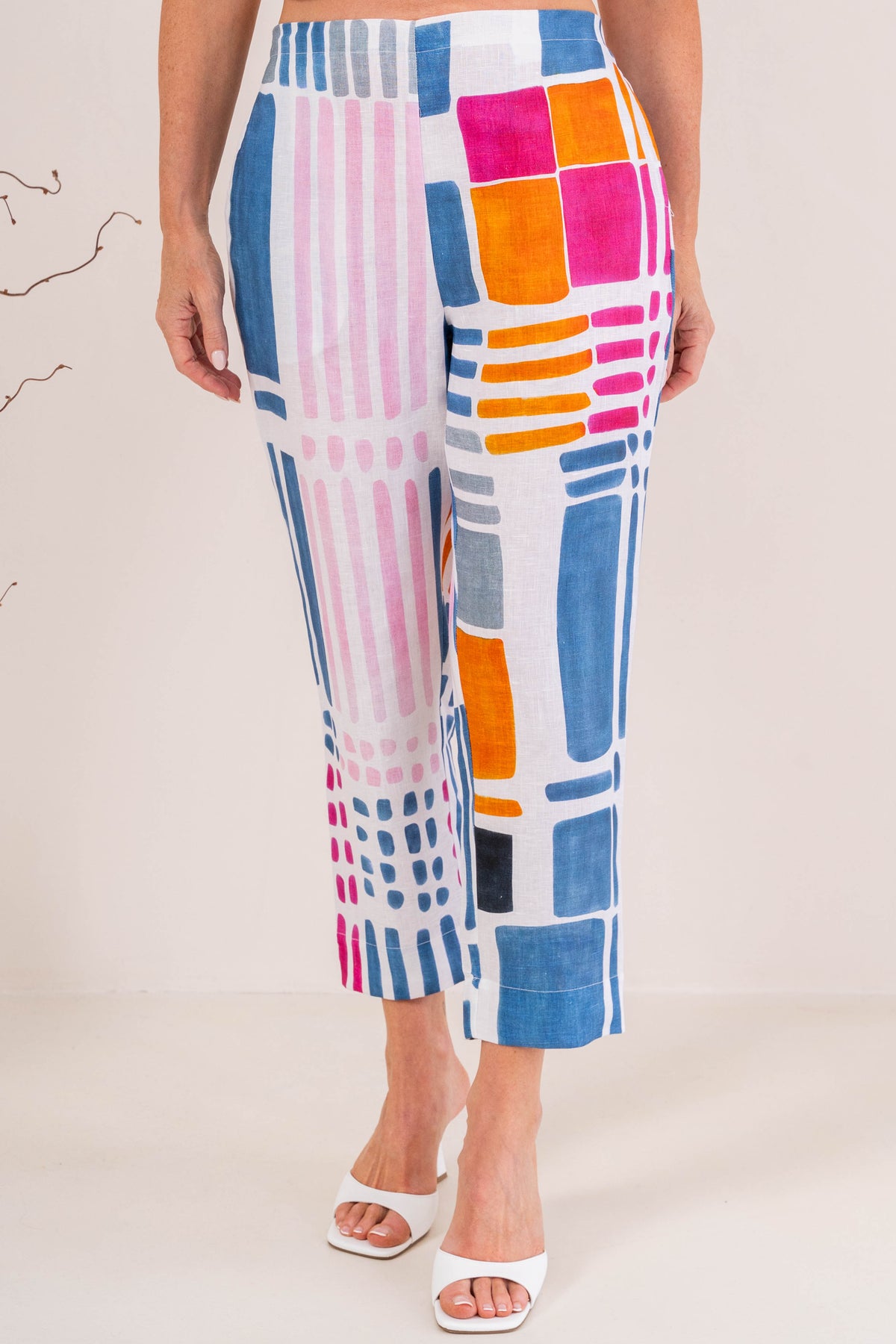 Woman modelling 100% linen See Saw pant in gallery print and in a 7/8 length. Modelling against a neutral studio background.