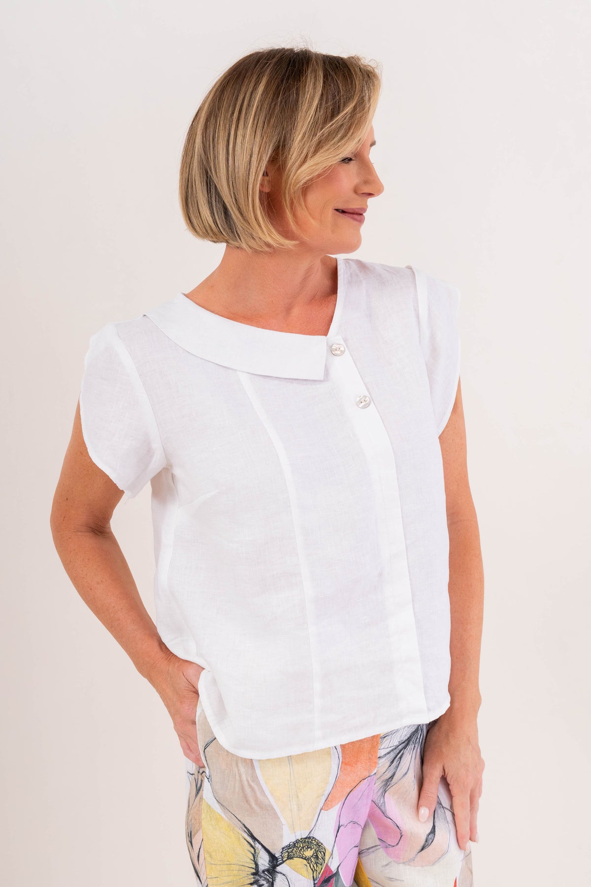 Model wearing see saw linen 2 button cowl neck top in navy.