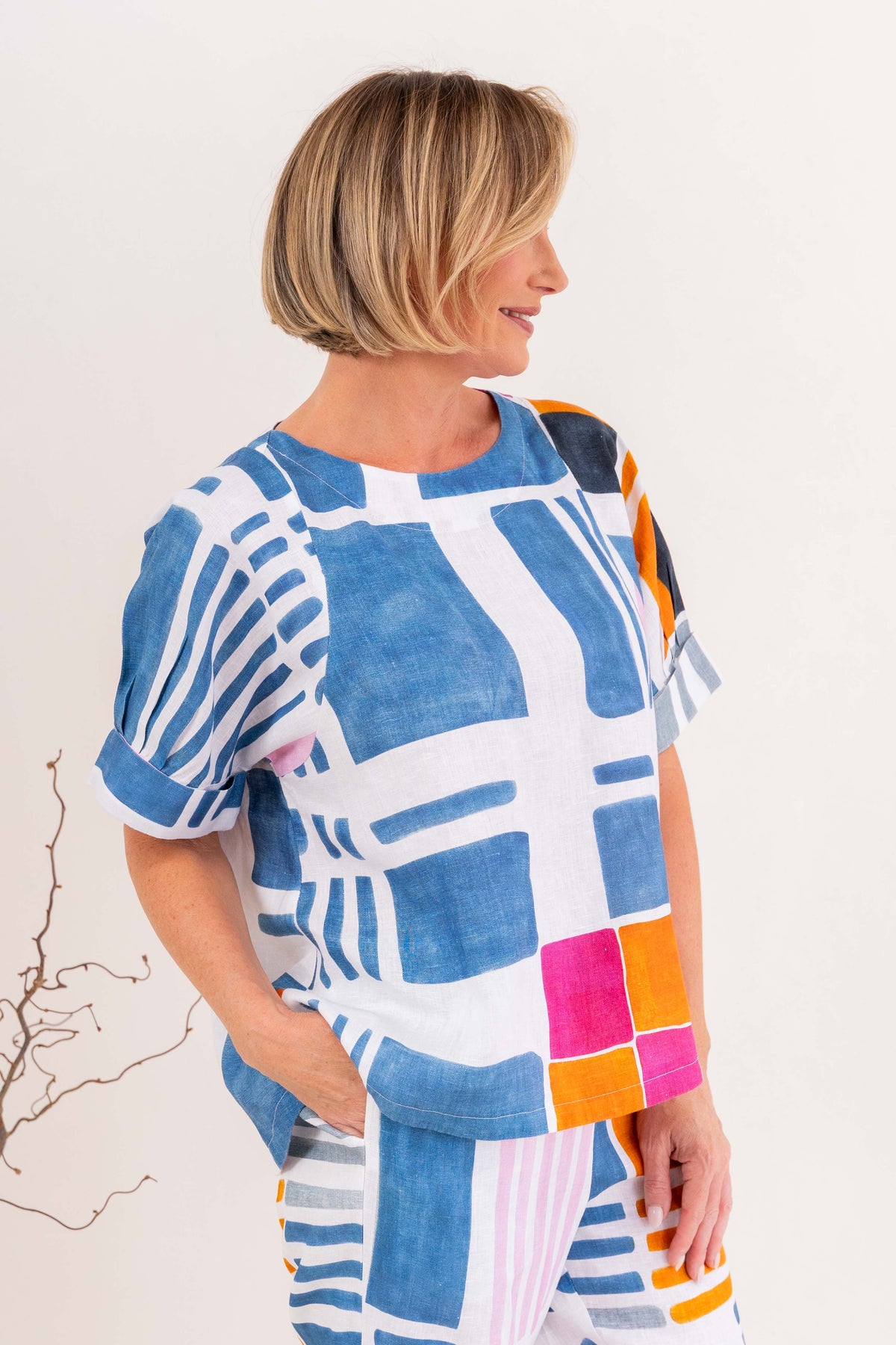 Woman modelling linen gallery print A line top with cuff sleeve by See Saw Clothing. Photo taken in a studio with a neutral background.