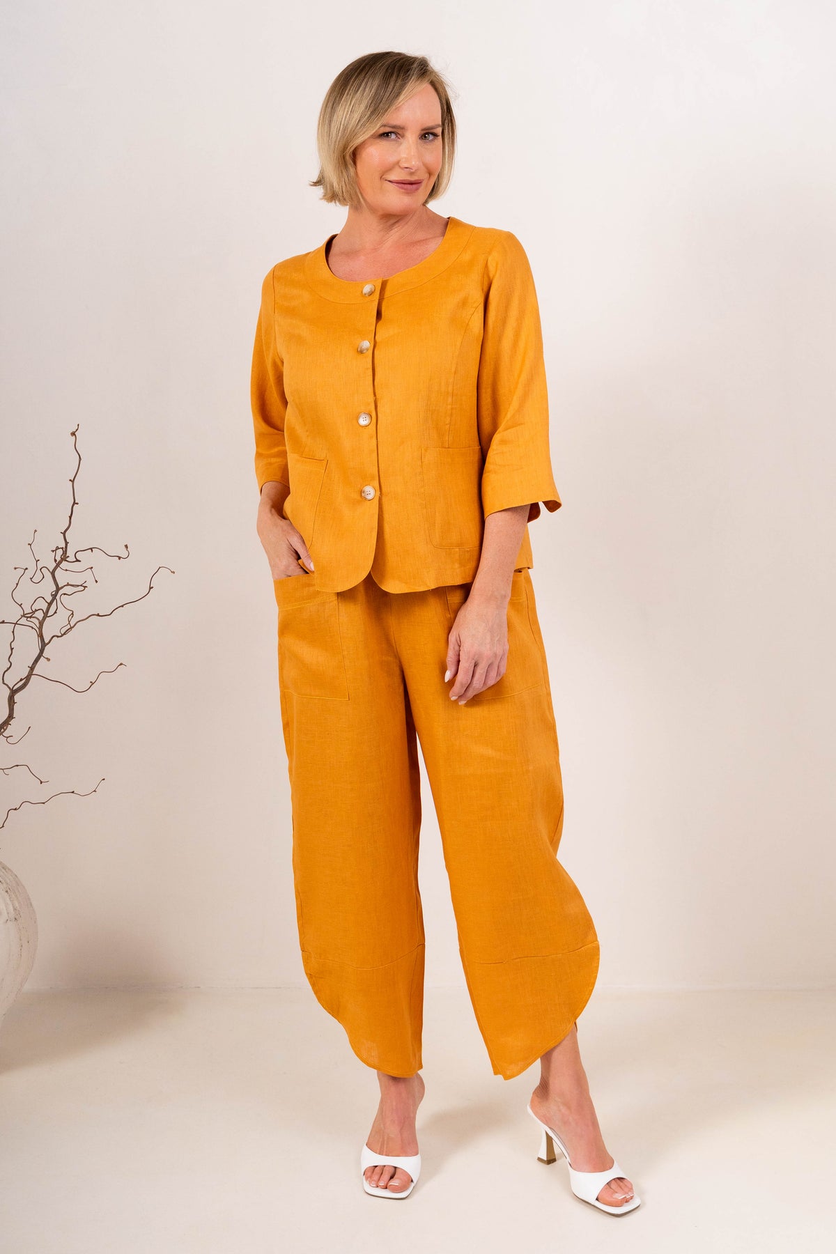 Women wearing 100% Linen See Saw top on stripe with a cap and 2 pocket pant in marigold against a neutral background