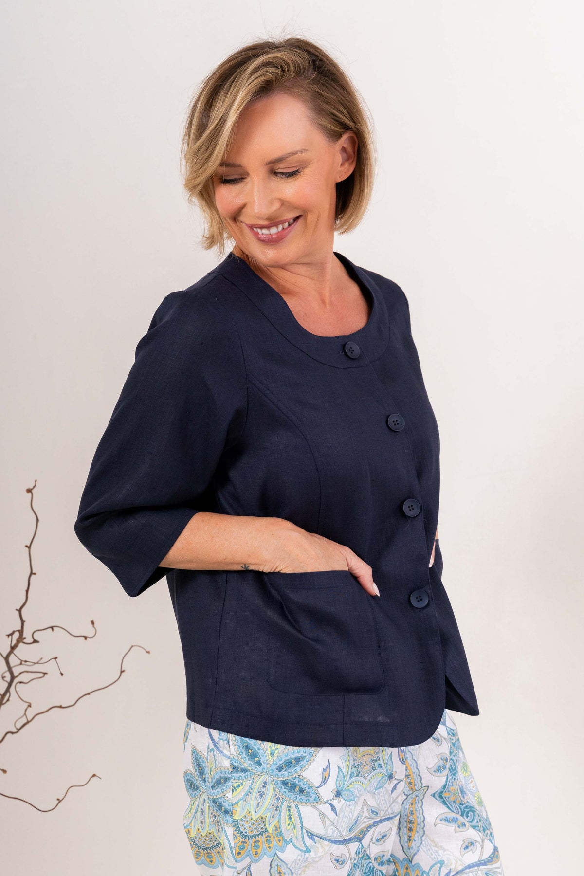 Woman modelling navy linen see saw utility jacket top against a plain background.