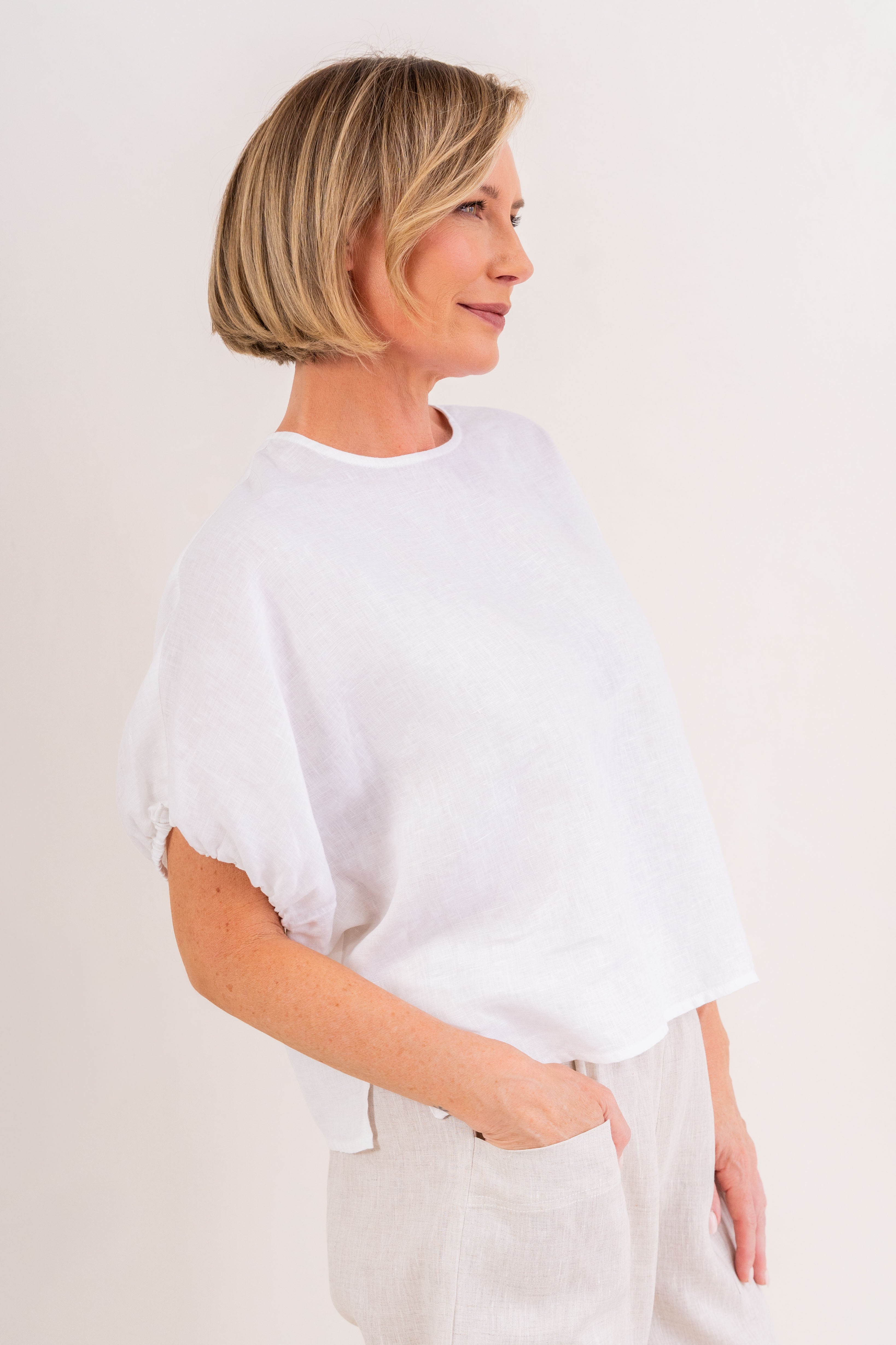 Model wearing white 100% linen elastic sleeve dress by See Saw