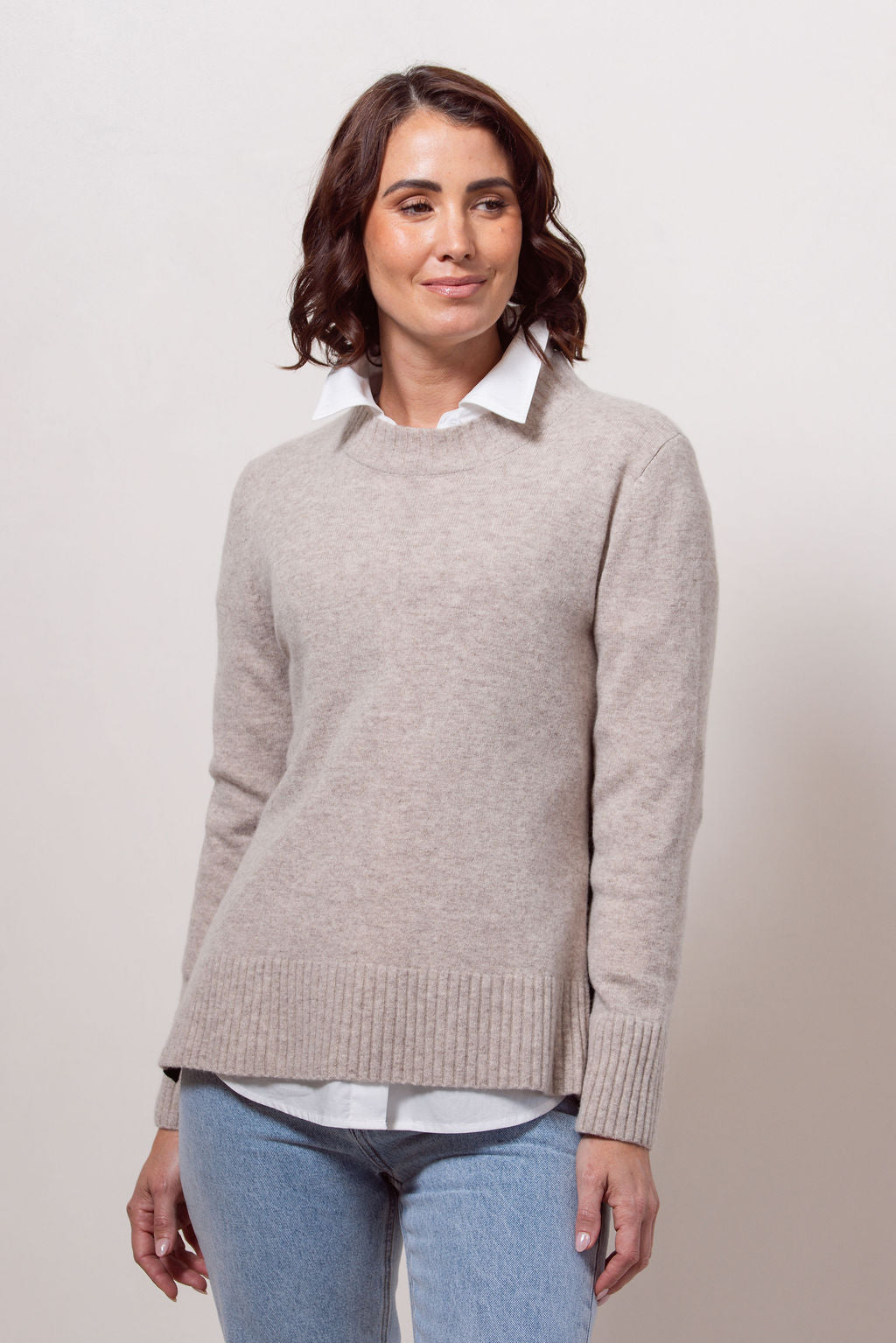 Woman wearing a Merino Wool See Saw sweater in wheat with Black accents on a plain background