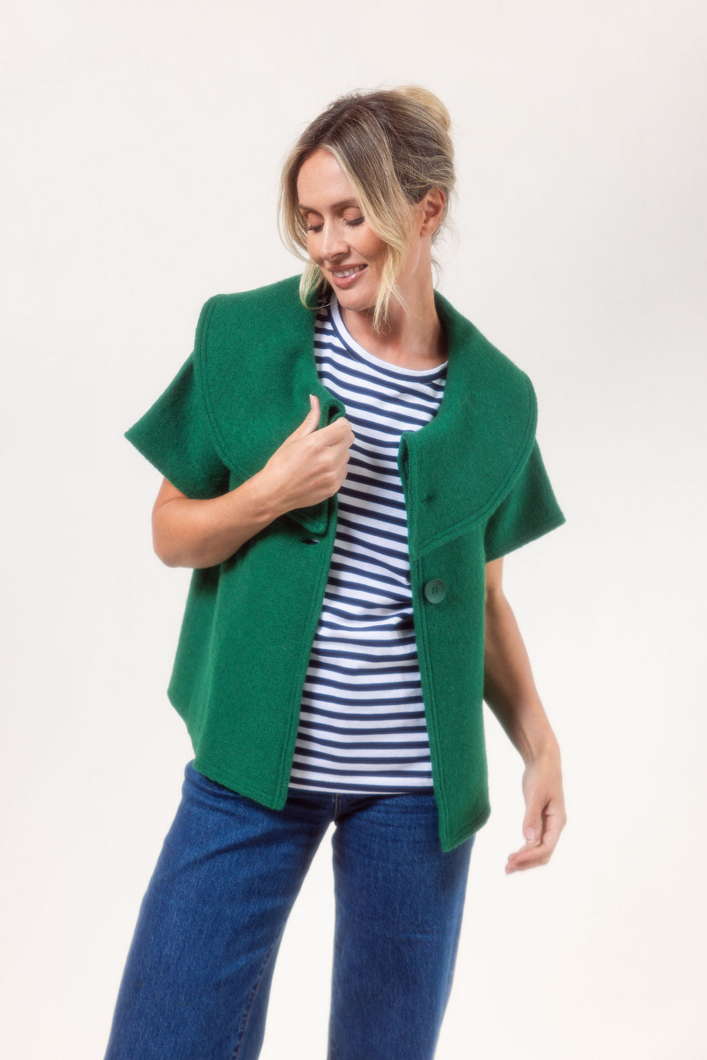 Woman wearing a See Saw Boiled Wool green coat against a plain background.