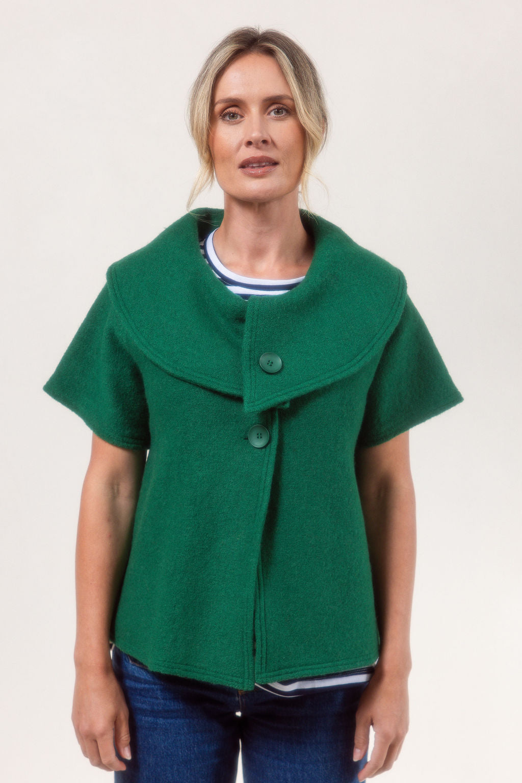 Woman wearing a See Saw Boiled Wool green coat against a plain background.