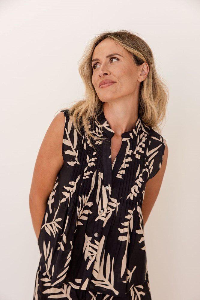 Woman wearing a black sleeveless top with beige leaf pattern against a white background. See Saw Cotton Sleeveless Pintuck Top