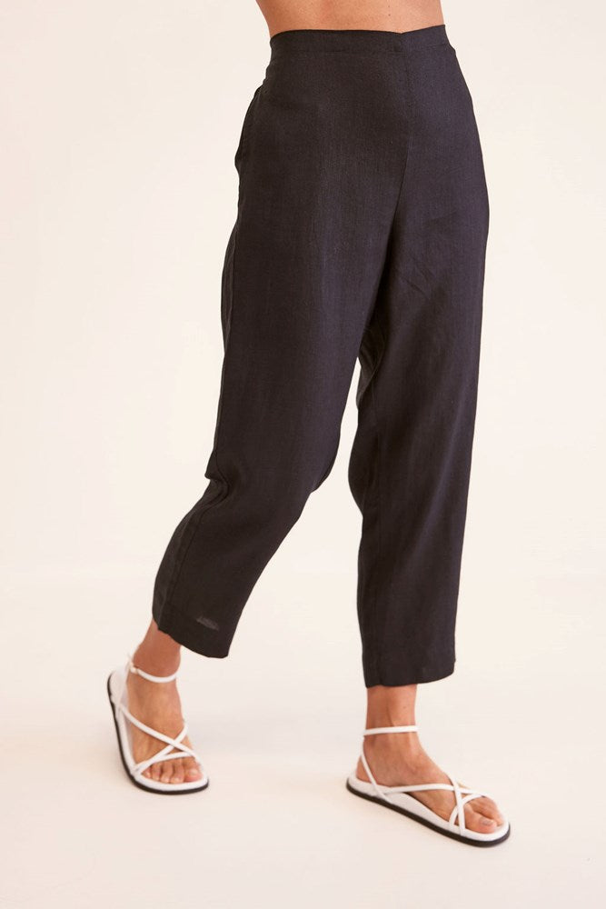 Person wearing black pants on a white background. See Saw 7/8 Length Pull On Pant