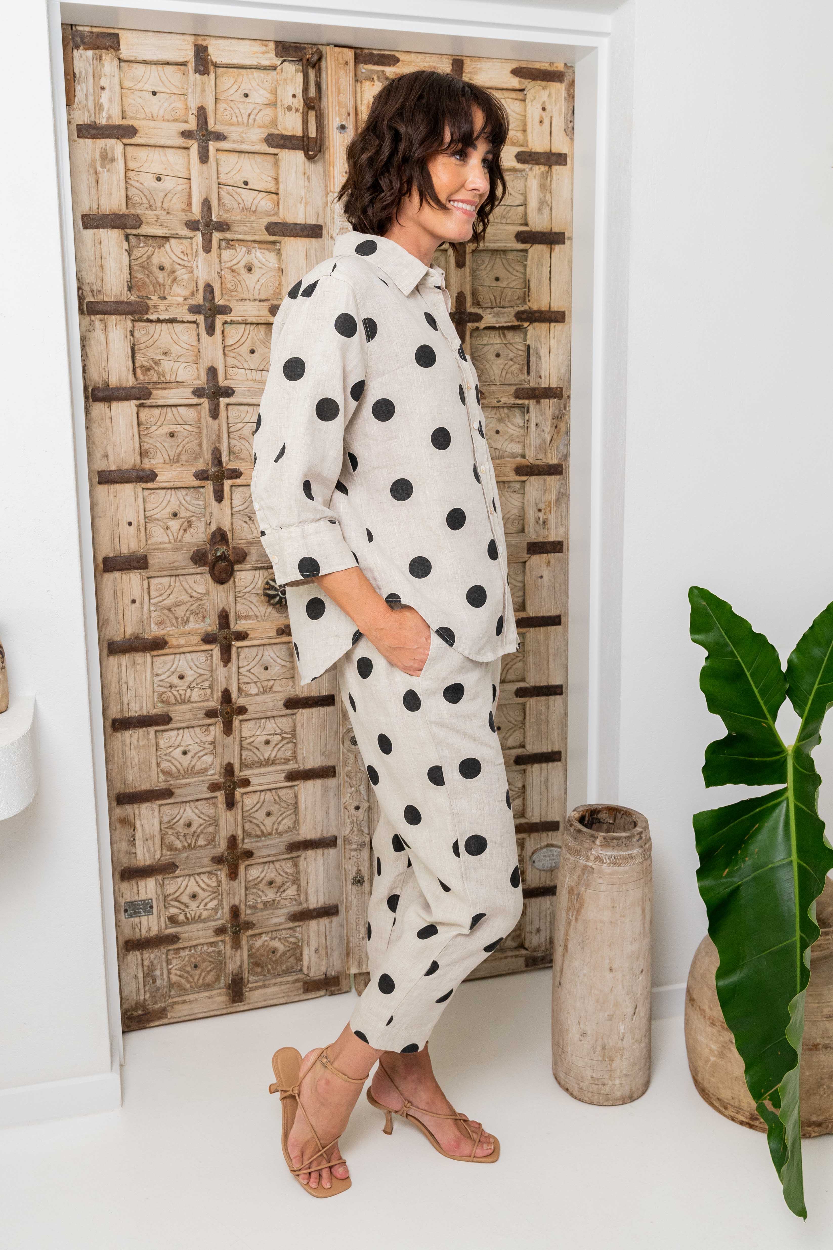 Woman in a polka dot outfit standing in a room with decorative elements. See Saw Linen Spot 3/4 Sleeve Shirt