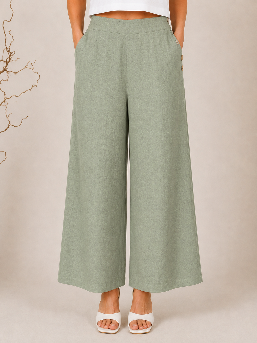 White wide-leg See Saw Palazzo linen pants shown on a model wearing white heeled sandals against a light beige background.