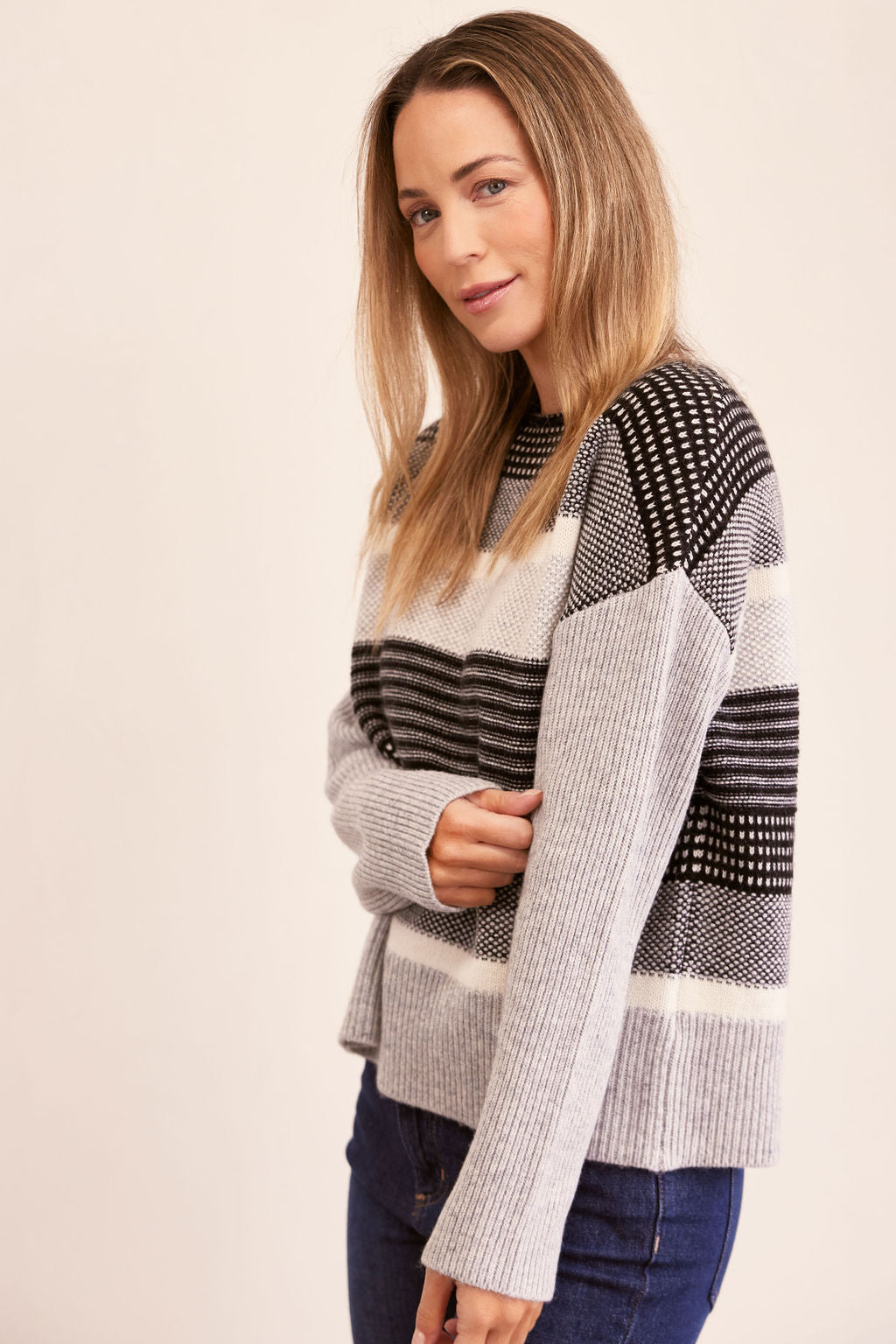 Woman wearing a jacquard patterned See Saw sweater against a plain background