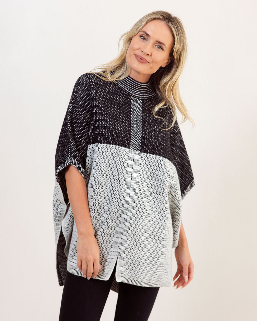 Woman wearing a black and gray See Saw Wool patterned poncho against a white background