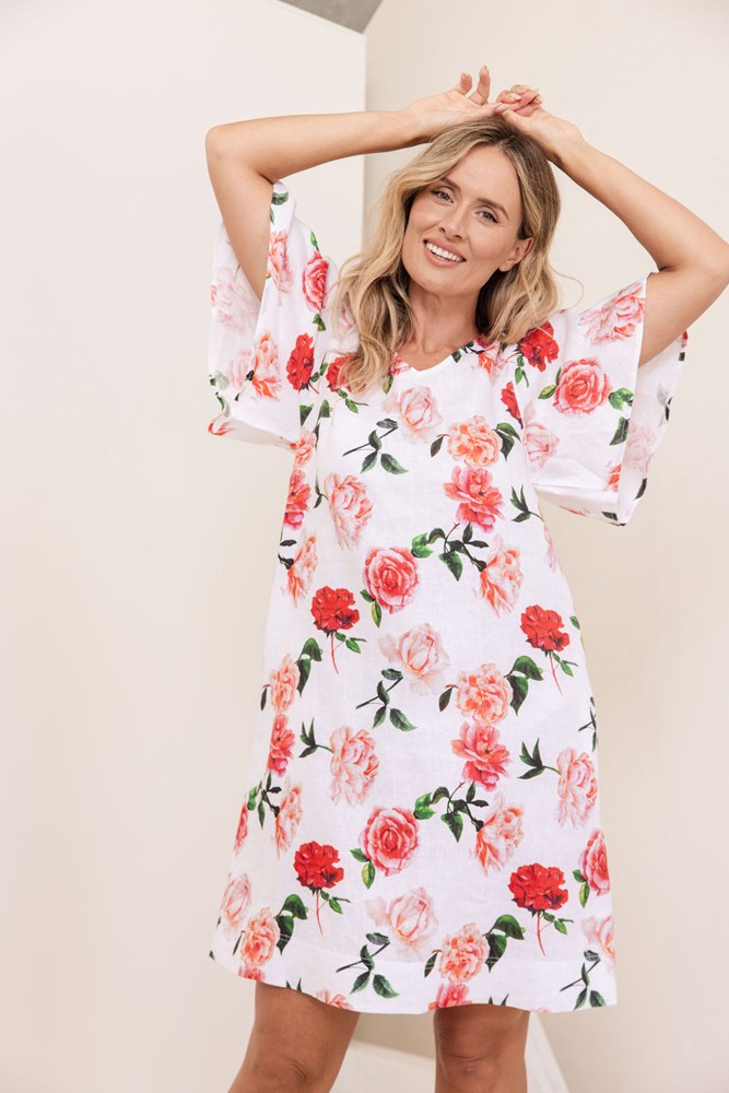 Woman wearing a See Saw linen flutter sleeve rose dress with a plain background