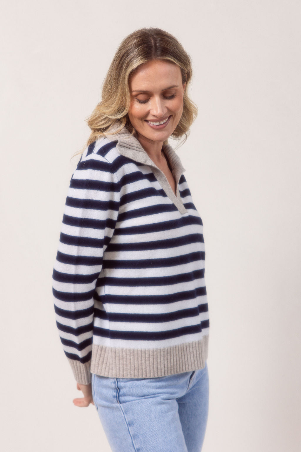 Woman wearing a see Saw Merino Wool navy and white striped sweater with a light gray collar against a plain background.