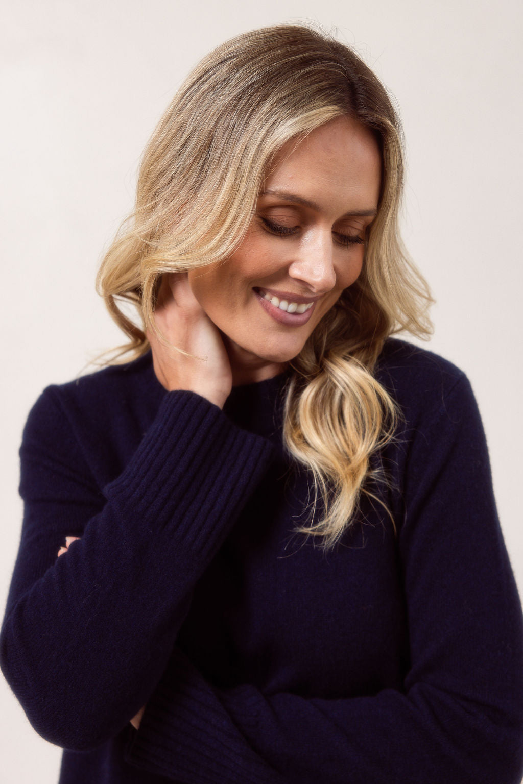 Woman wearing a Merino Wool See Saw sweater in navy sweater with red accents on a plain background