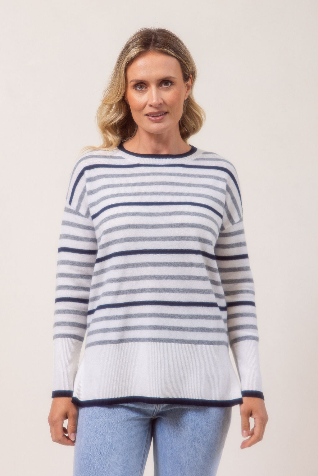 Woman wearing a Merino Wool striped See Saw sweater against a plain background