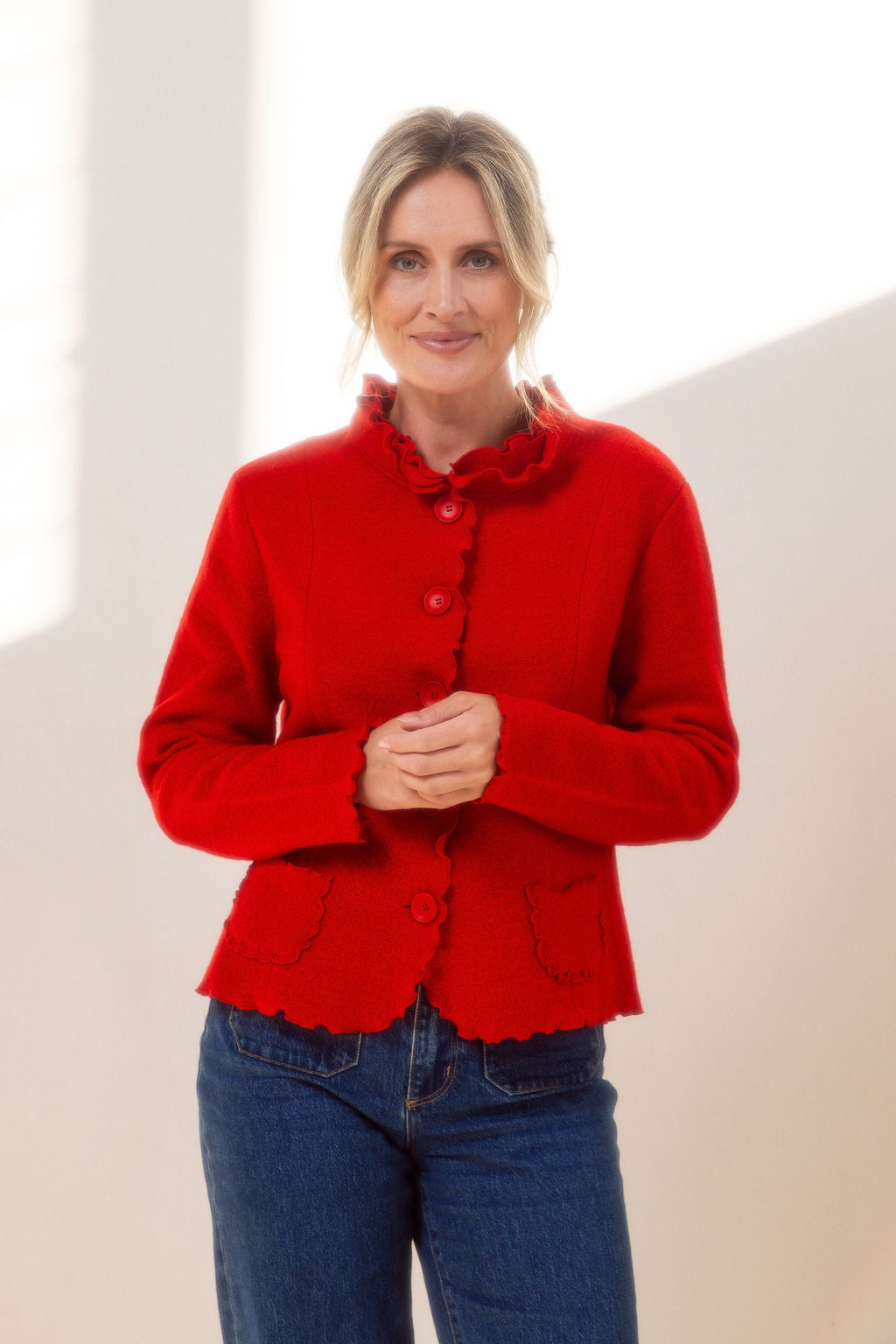 Woman wearing a See Saw red colored boiled wool jacket with a white background