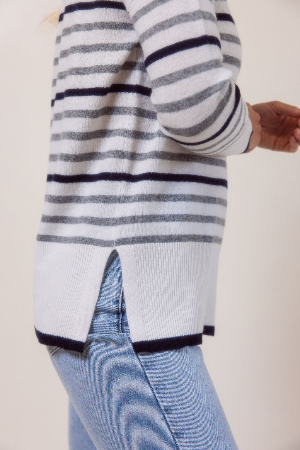 Woman wearing a Merino Wool striped See Saw sweater against a plain background
