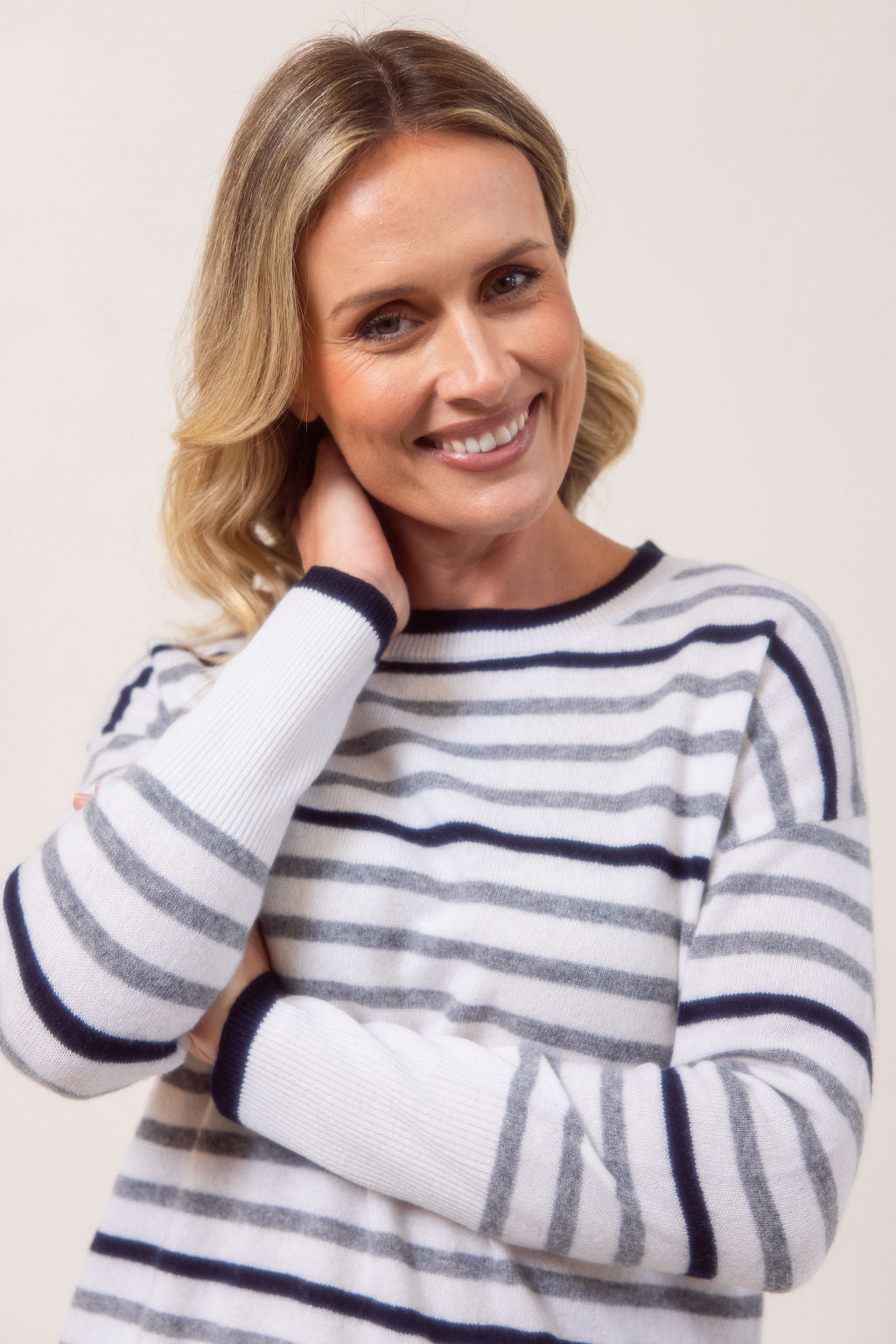 Woman wearing a Merino Wool striped See Saw sweater against a plain background