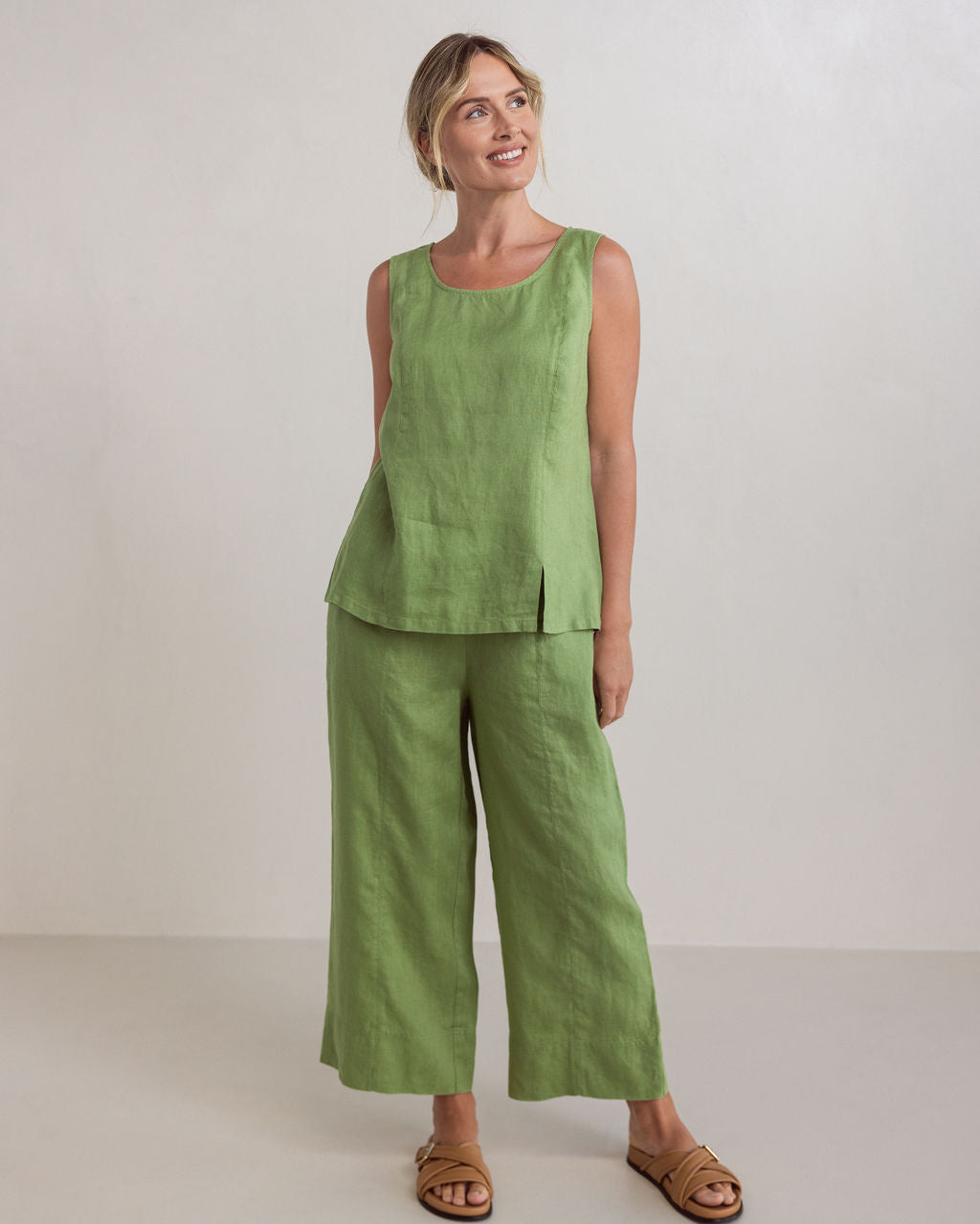Woman wearing See Saw linen wide leg pants in pistachio and matching top with brown sandals against a white background