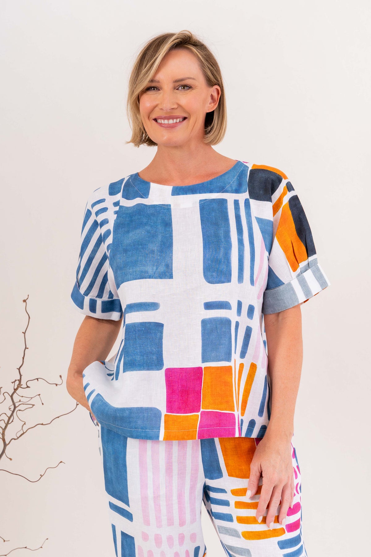 Woman modelling linen gallery print A line top with cuff sleeve by See Saw Clothing. Photo taken in a studio with a neutral background.