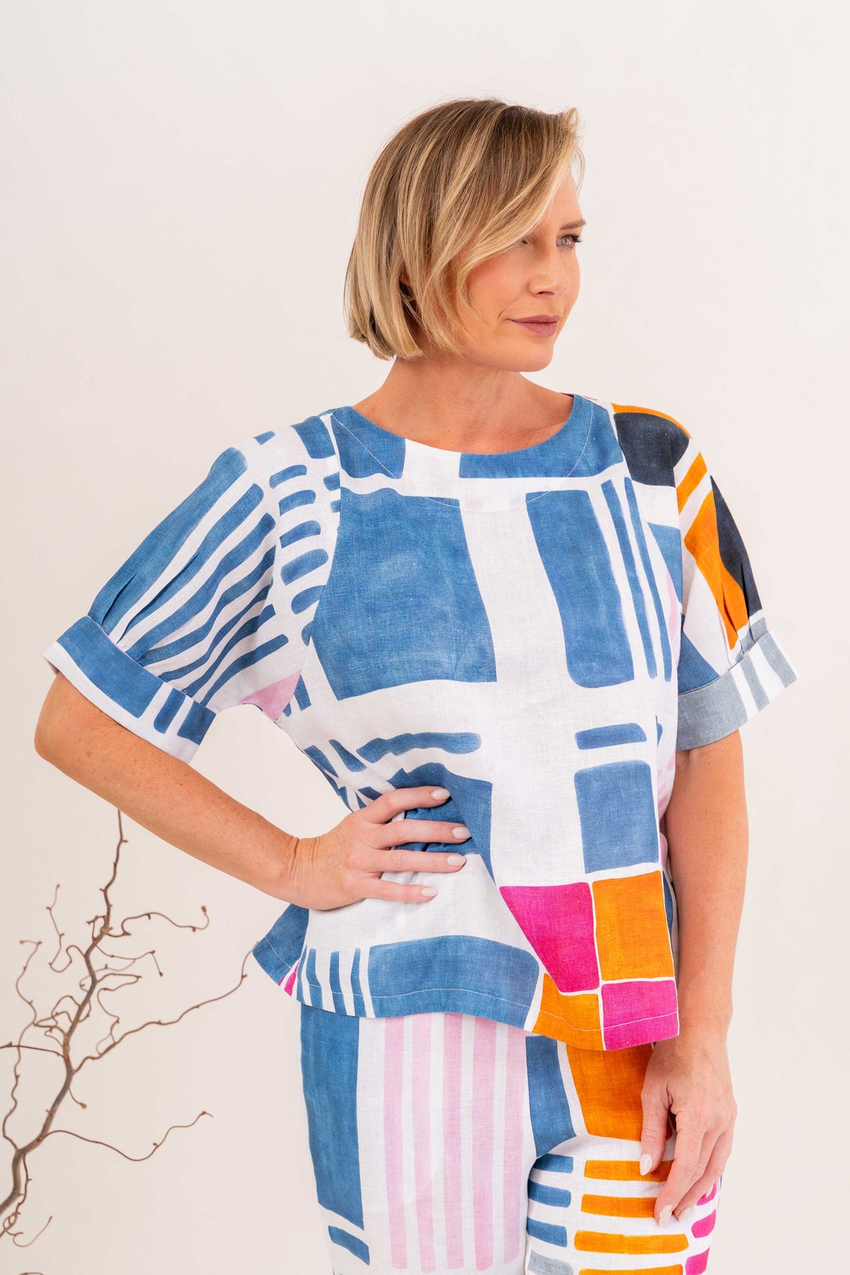 Woman modelling linen gallery print A line top with cuff sleeve by See Saw Clothing. Photo taken in a studio with a neutral background.