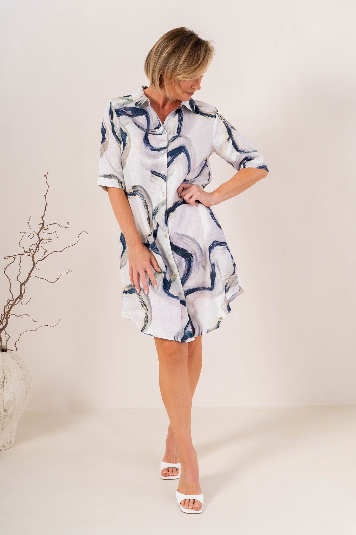 Woman modelling see saw linen shirtmaker style dress in riverstone print in studio setting.